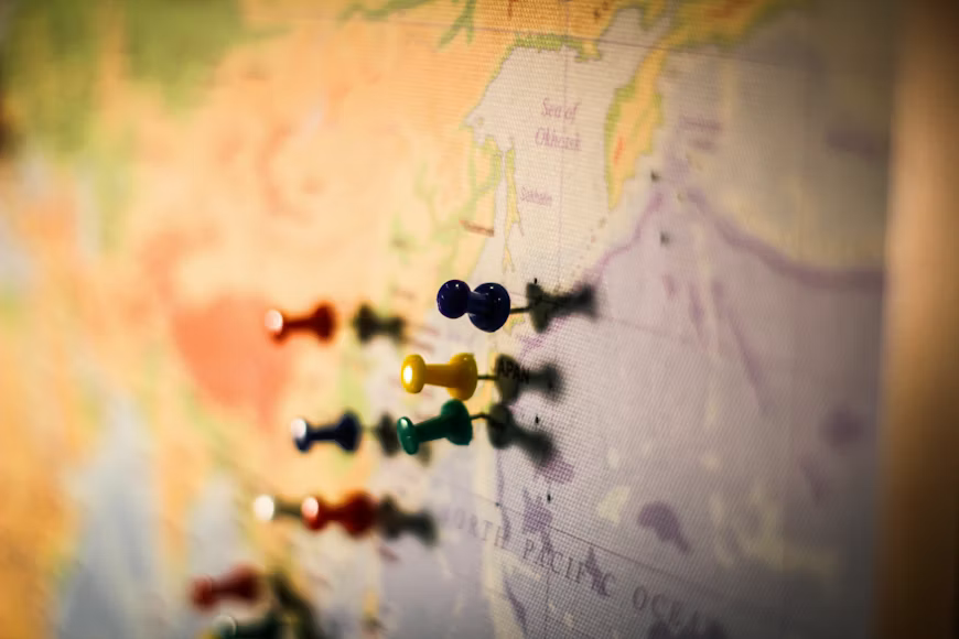 Coloured pushpins marking multiple locations on a world map, representing Sentinel's connected international healthcare routes.
